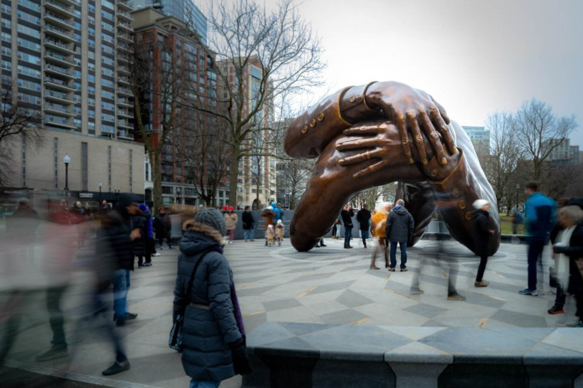 Eine Aufnahme der Bronzeskulputur The Embrace in Boston, die sich umschlingende Arme zeigt.